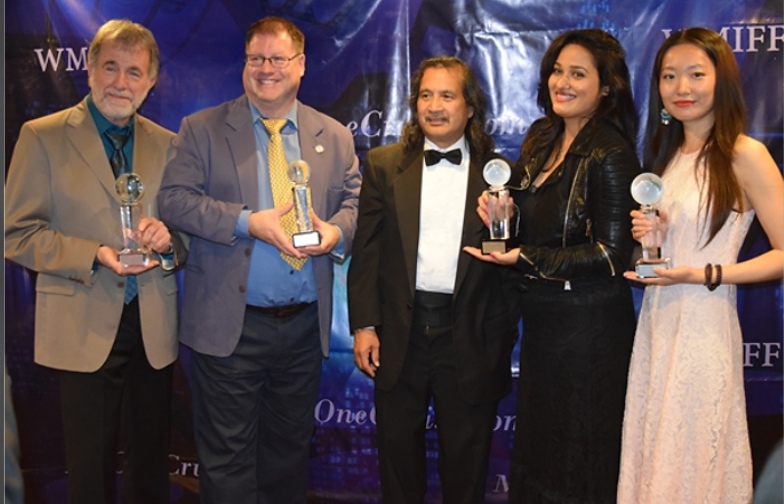 People holding trophies at a World Music & Independent Film Festival event.